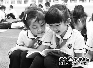 4月23日,在中国广西南宁市滨湖路小学,学生们在篮球场上阅读自己喜爱的书籍。